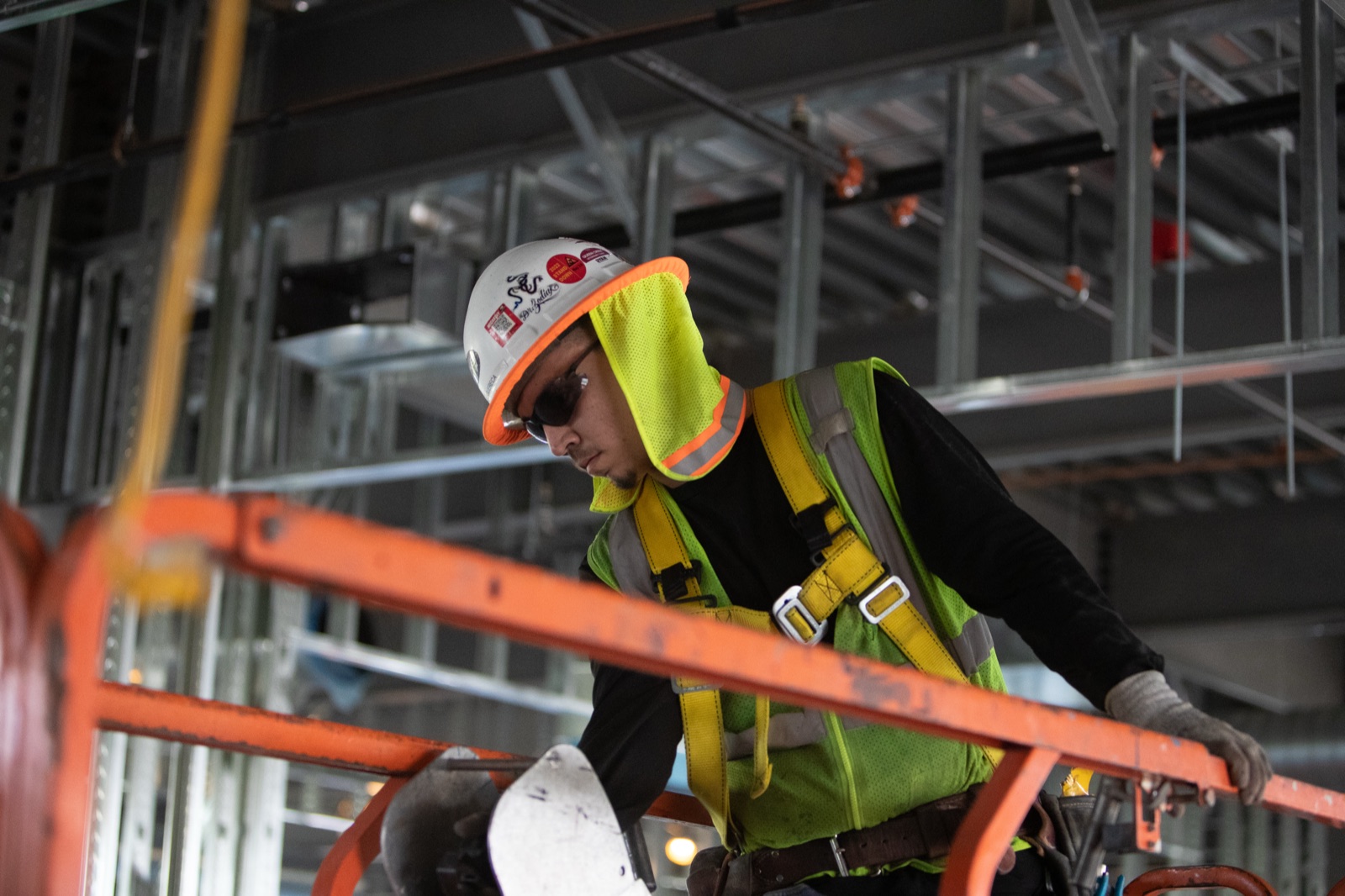 Better Built Arizona tradesman working on a lift beneath steel stud framing