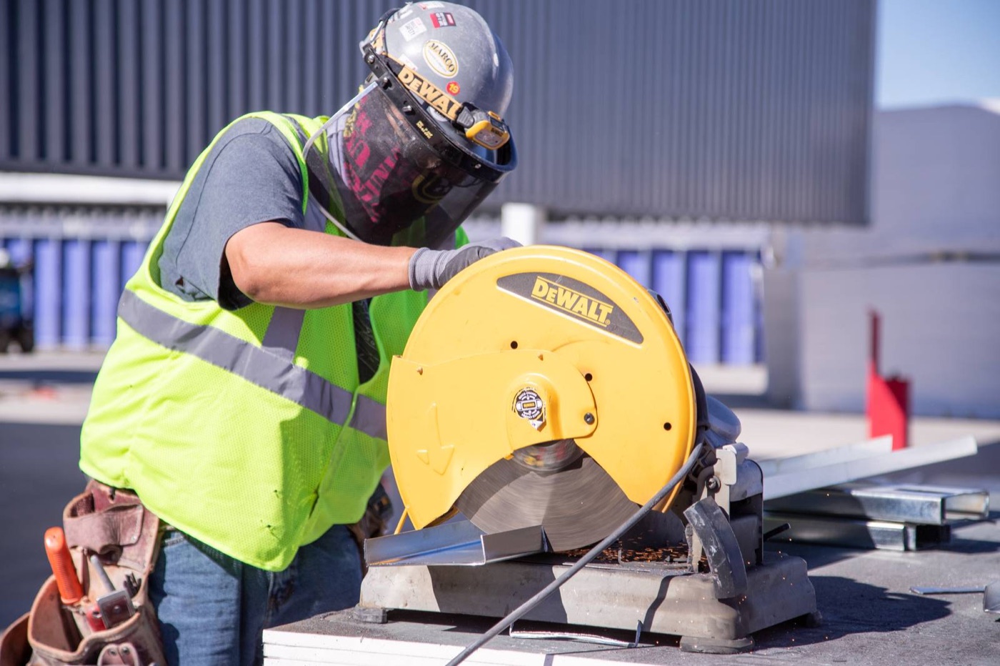 Tradesman cutting steel stud with a chop saw