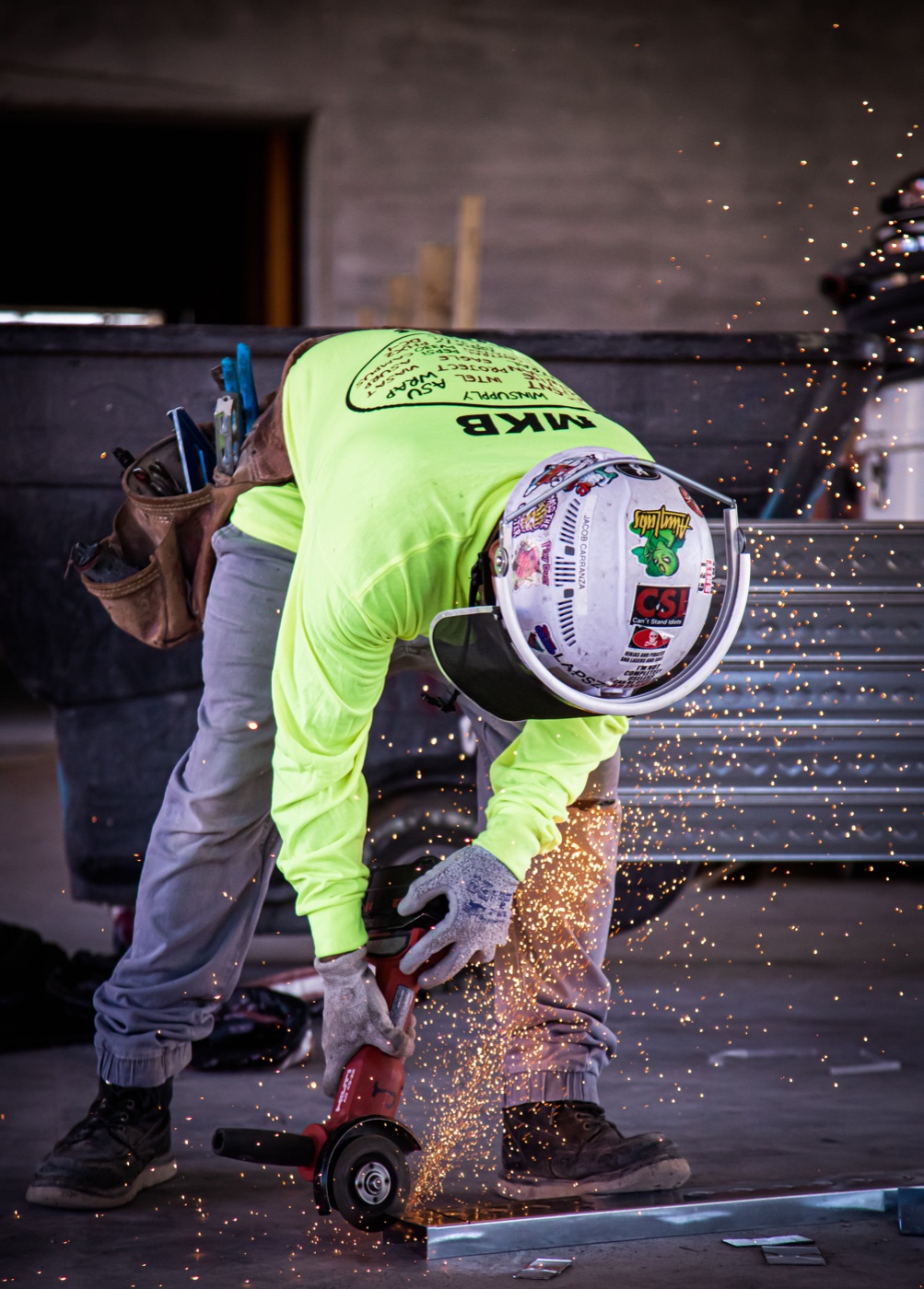 MKB tradesman cutting steel track with sparks flying